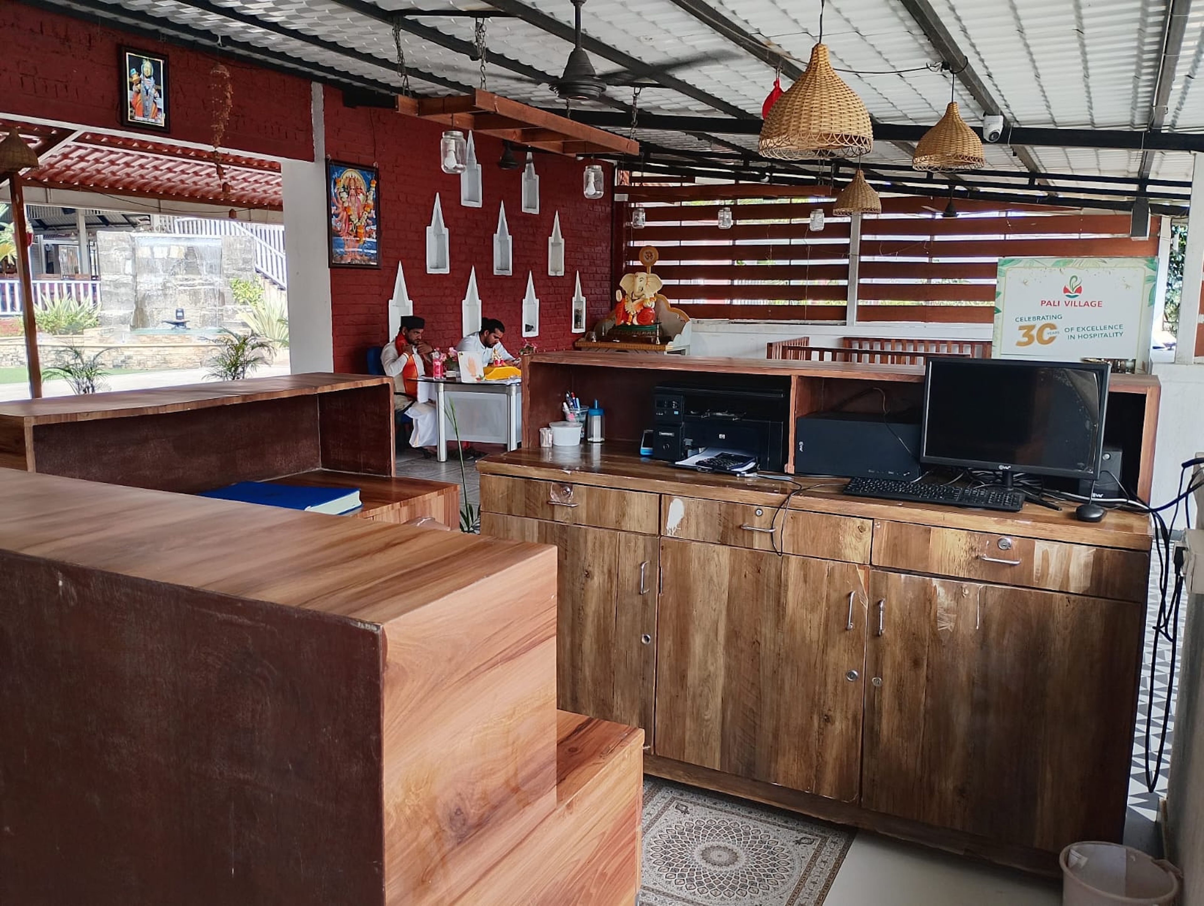 Un restaurant avec un comptoir en bois, un ordinateur et un panneau indicateur.