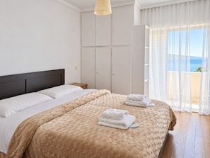 A hotel room with a bed, a wardrobe, and a view of the sea. - Athens Riviera Sea View - Piraeus (Pireas)