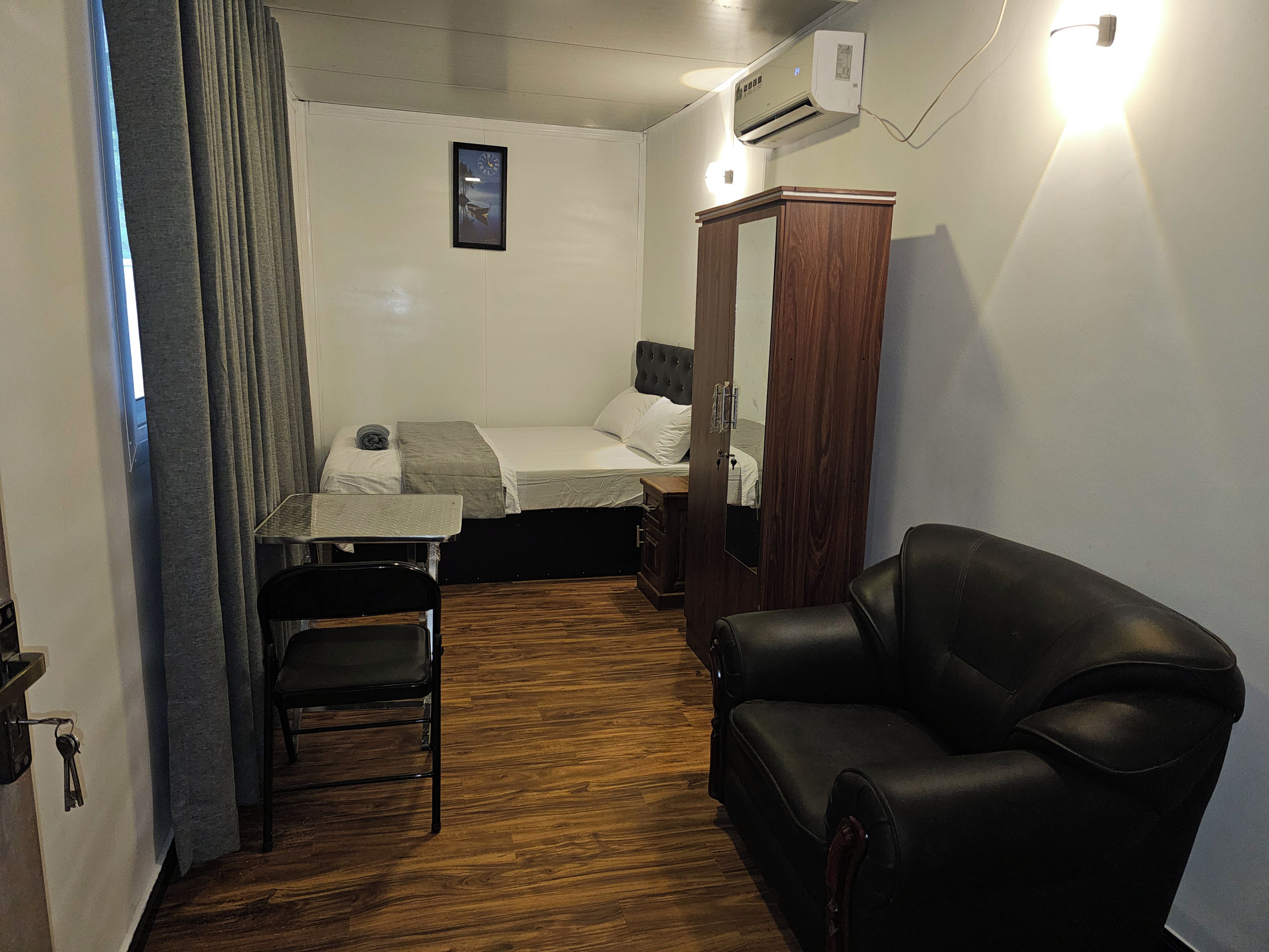 Una habitación pequeña con cama, escritorio, silla y armario.