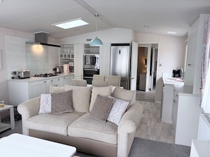 A modern kitchen with a built-in oven, microwave, and gas stove. - Ambleside Lodge Sleeps 6 With Parking and Wrap Around Balcony (Porthmadog)