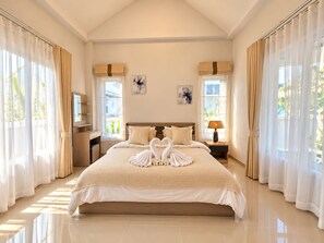 Ruime slaapkamer met een groot bed, twee nachtkastjes en een raam met gordijnen.