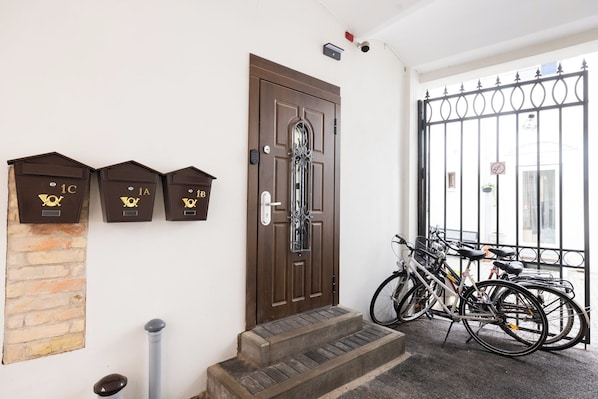 A door with mail slots, a set of steps, and bicycles parked outside. - Wagner 12 Old Town Apartment - 2 bedrooms, sleeps 5, Wi-Fi (Rīga)