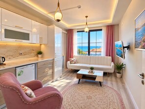 Una sala moderna con un sofá, una mesa de centro y un sillón rosa.
