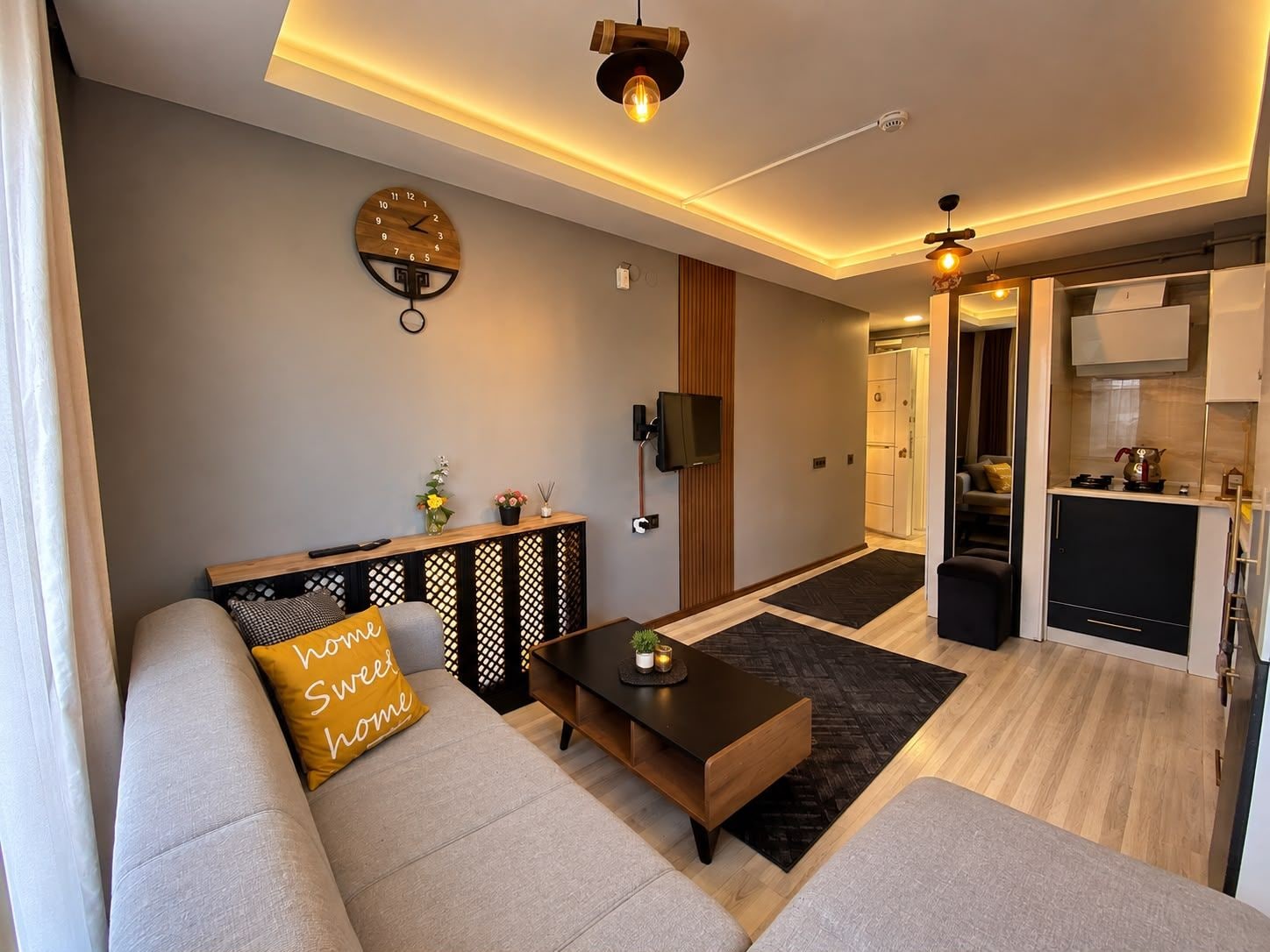 A modern living room with a sofa, coffee table, and a wall clock.