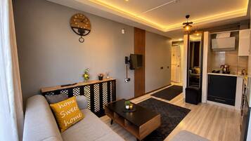 A modern living room with a sofa, coffee table, and a wall clock.