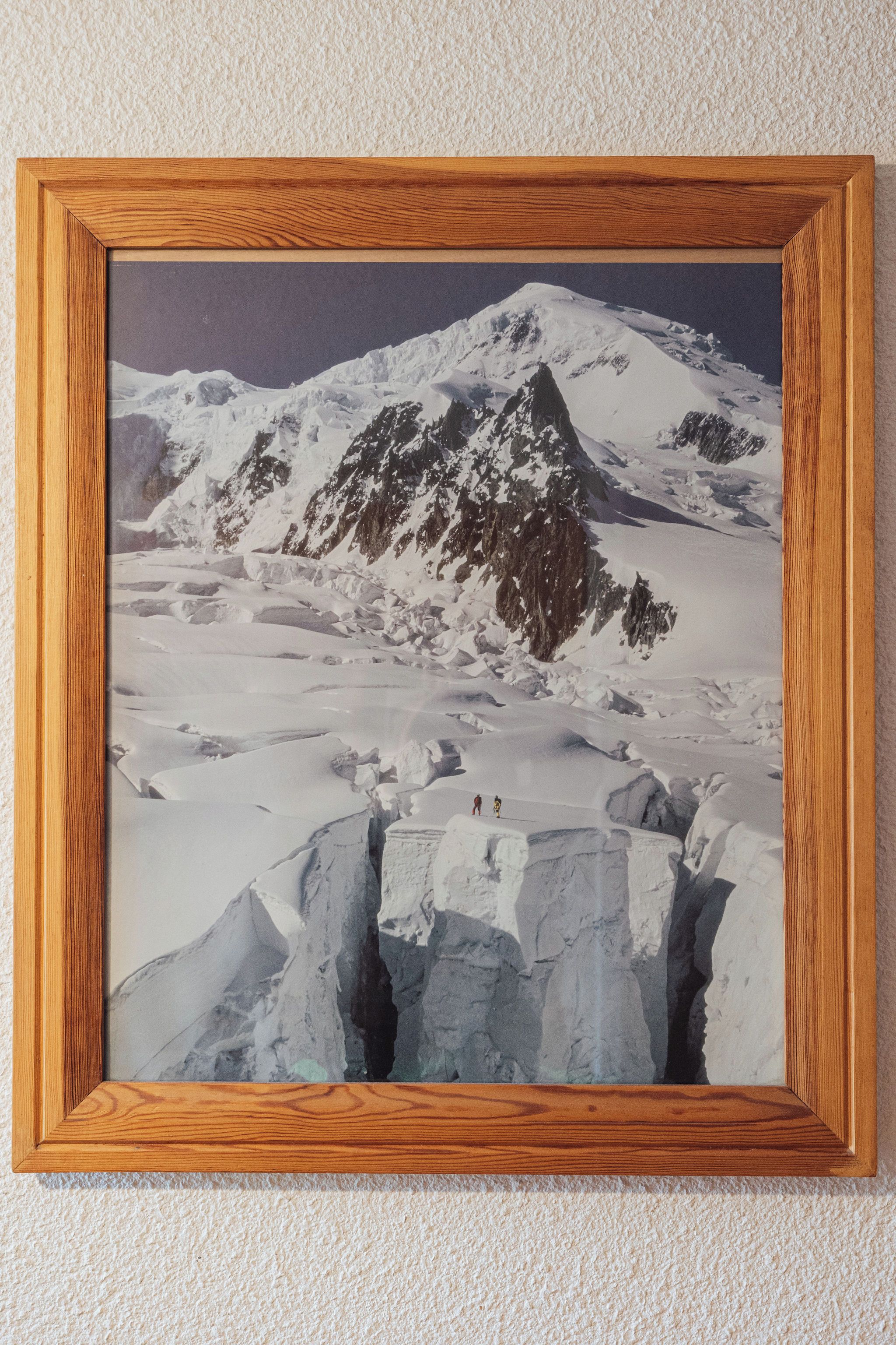 A framed landscape painting of a snowy mountain scene.