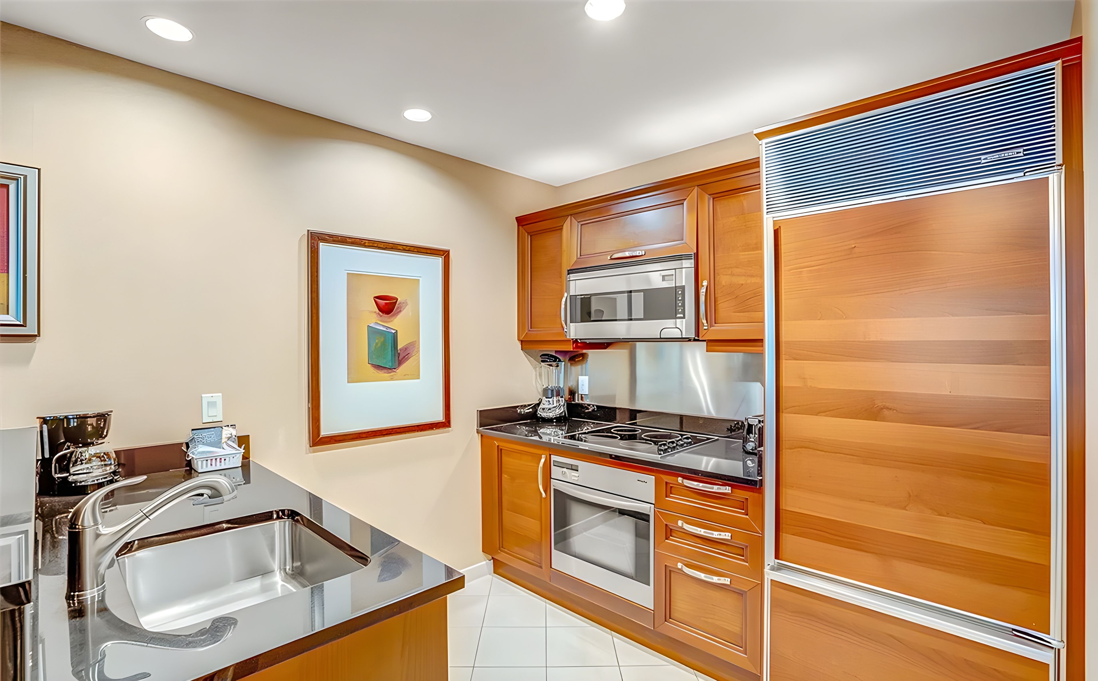 A modern kitchen with stainless steel appliances, wooden cabinetry, and a tiled backsplash.