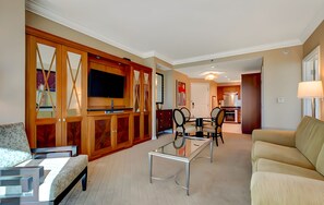 Una sala de estar moderna con un sofá, una mesa de centro de vidrio y un televisor montado en un mueble de madera.