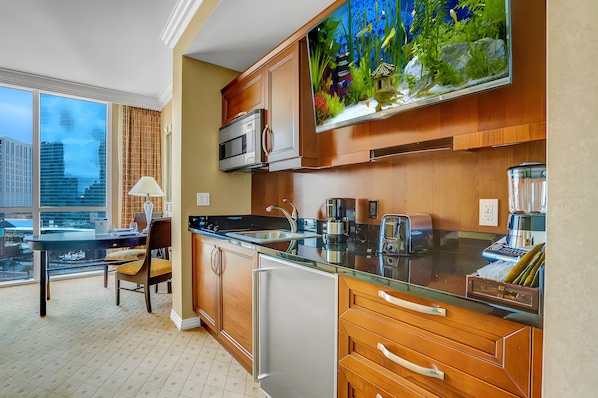 A modern kitchen with a large window, a microwave, a sink, and a refrigerator. - 2 Bedroom 3 BTH balcony Cojoined collection at MGM SIGNATURE StripSuite Hotel & Resort - NO RESORT FEE (Las Vegas)