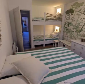 A bunk bed room with a desk and dresser, a door leading to another room, and a wall with a nature-themed mural. - New Listing (Gujan-Mestras)
