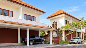 Una casa de dos pisos con un camino de entrada cubierto y un garaje.