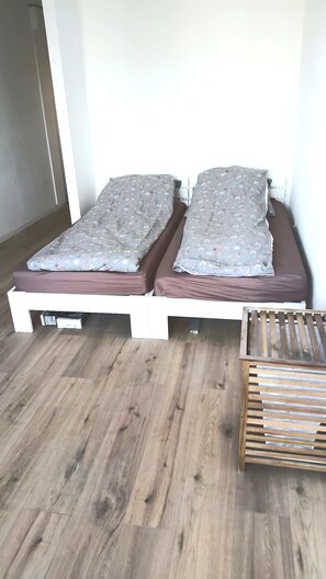 Ein Doppelbett mit Holzrahmen und einer Matratze mit Blumenmuster.