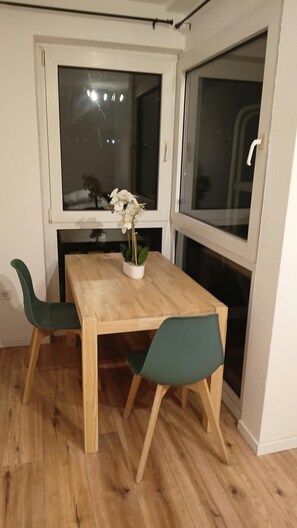 Ein Essbereich mit einem Holztisch, zwei Stühlen und einem Blumentopf.