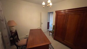 A room with a wooden table, a chair, a lamp, and a wardrobe. - New Listing (Brive-la-Gaillarde)