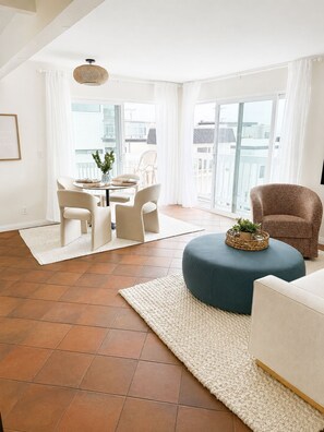 A modern living room with a dining area, large windows, and a view of the city. - Steps to the Beach, Quiet, New, Intuit, Crypto, Sofi, LAX, Venice, Santa Monica (Manhattan Beach)