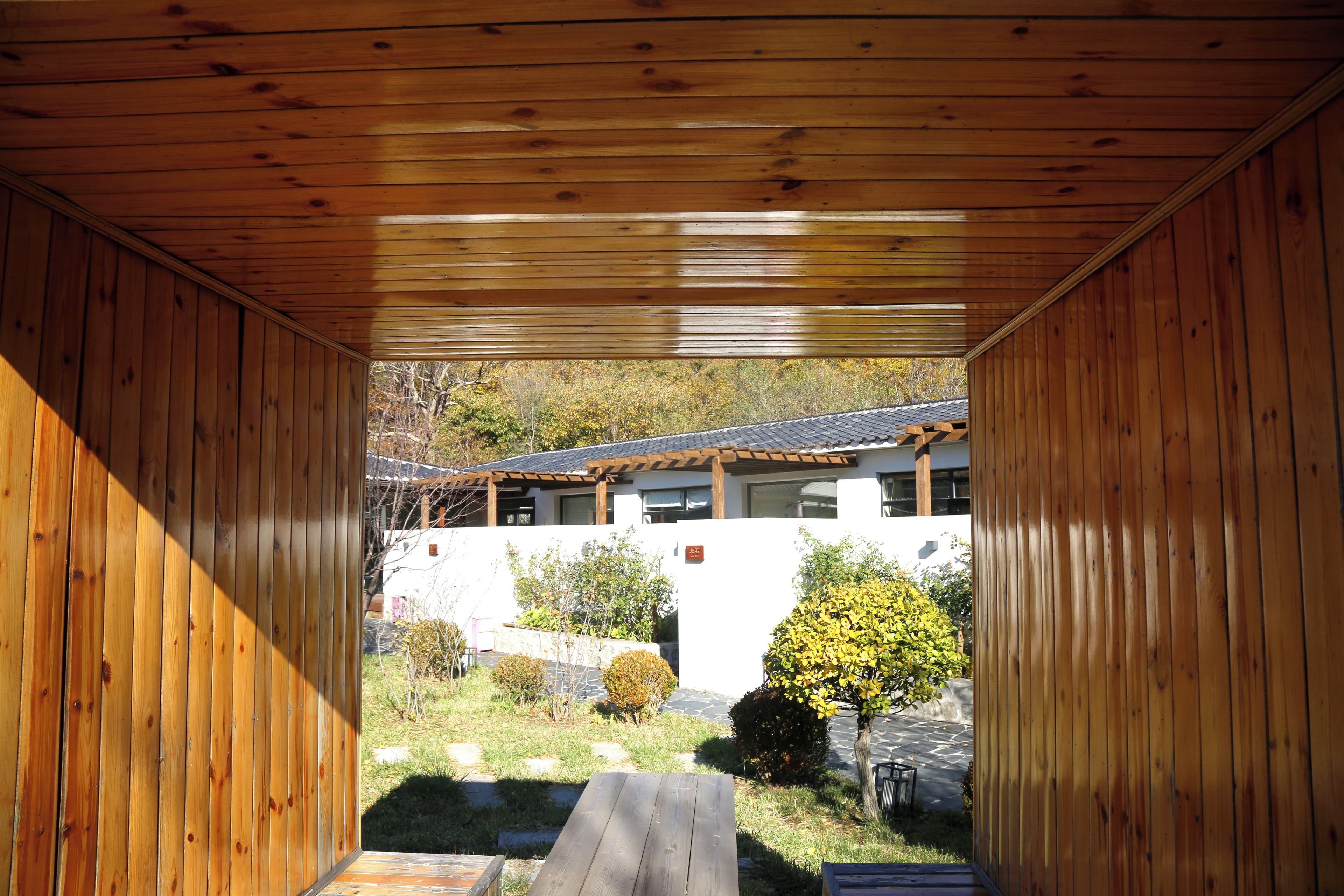 Una estructura de madera con vistas a un edificio y un jardín.