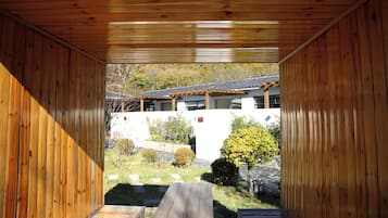Una estructura de madera con vistas a un edificio y un jardín.