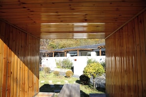 Estrutura de madeira com vista para um edifício e um jardim.