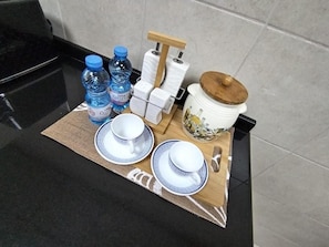 A table with a placemat, two white cups with blue patterns, two water bottles, a tea set, and a decorative ceramic pot. - Zigzag Tower B-Honeymoon Suit, 2 Bedroom at 32 floor In Pearl-3201B (Lusail)