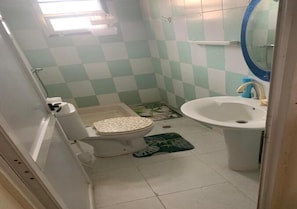Uma casa de banho pequena com sanita, bidé e lavatório.