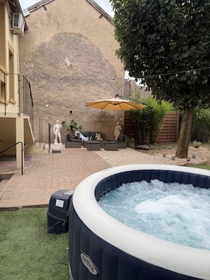 An outdoor hot tub with a stone wall in the background, a staircase, and outdoor furniture. - New Listing (Pouilly-sur-Loire)