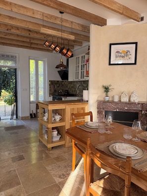 A dining area with a wooden table set for four, a fireplace, and a kitchen in the background. - New Listing (Pouilly-sur-Loire)