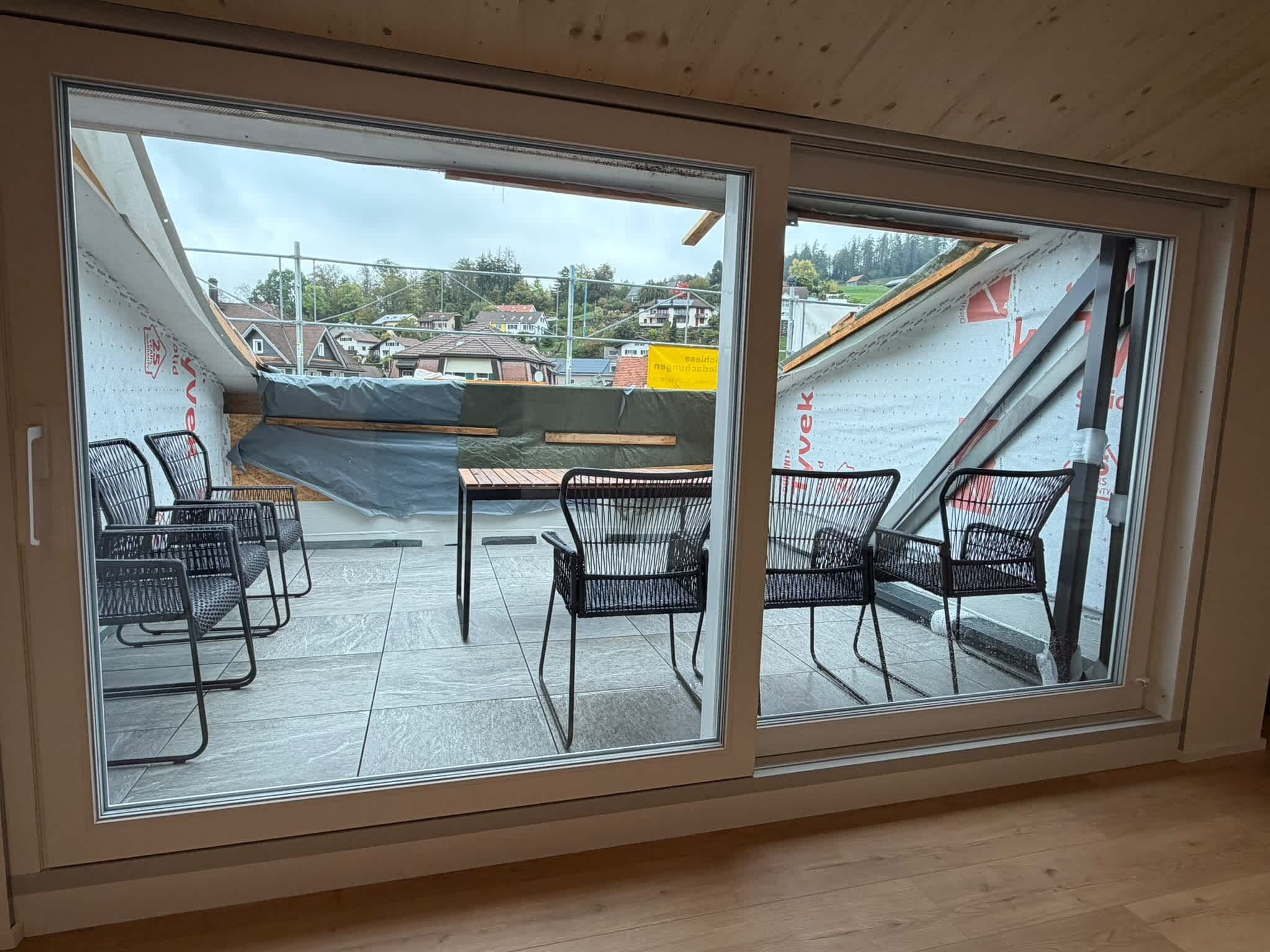 Ein Zimmer mit einer großen Schiebetür, die auf eine Außenpatio mit Blick auf eine Wohngegend führt.