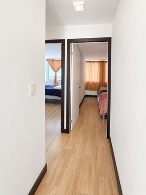 A hotel room with a bed, a window with curtains, and a view of the city. - Refugio Quiteño (Quito)