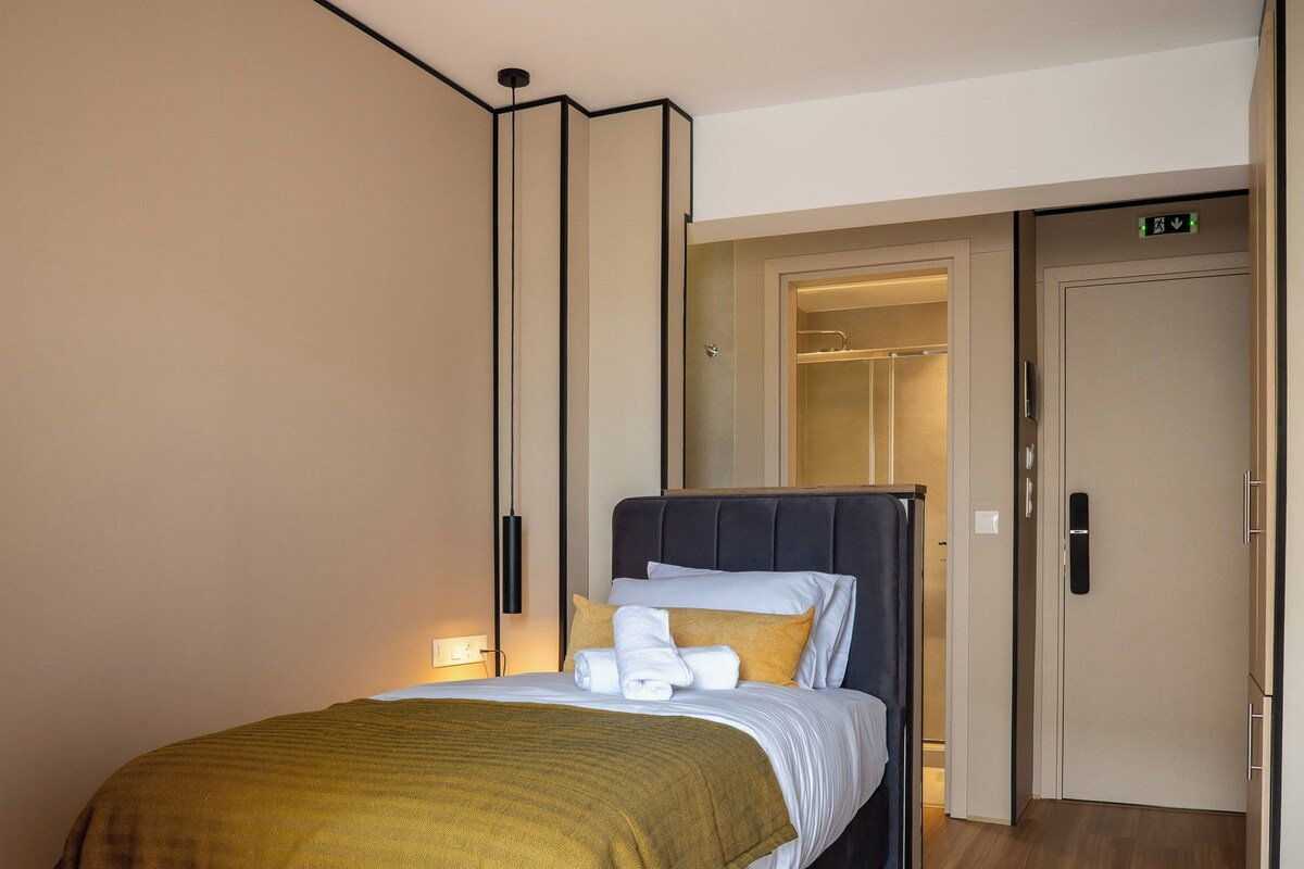 Een moderne hotelkamer met een groot bed, een nachtkastje en een kledingkast.
