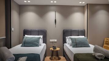 Een moderne hotelkamer met twee bedden, een kleintje tafeltje en een spiegel.