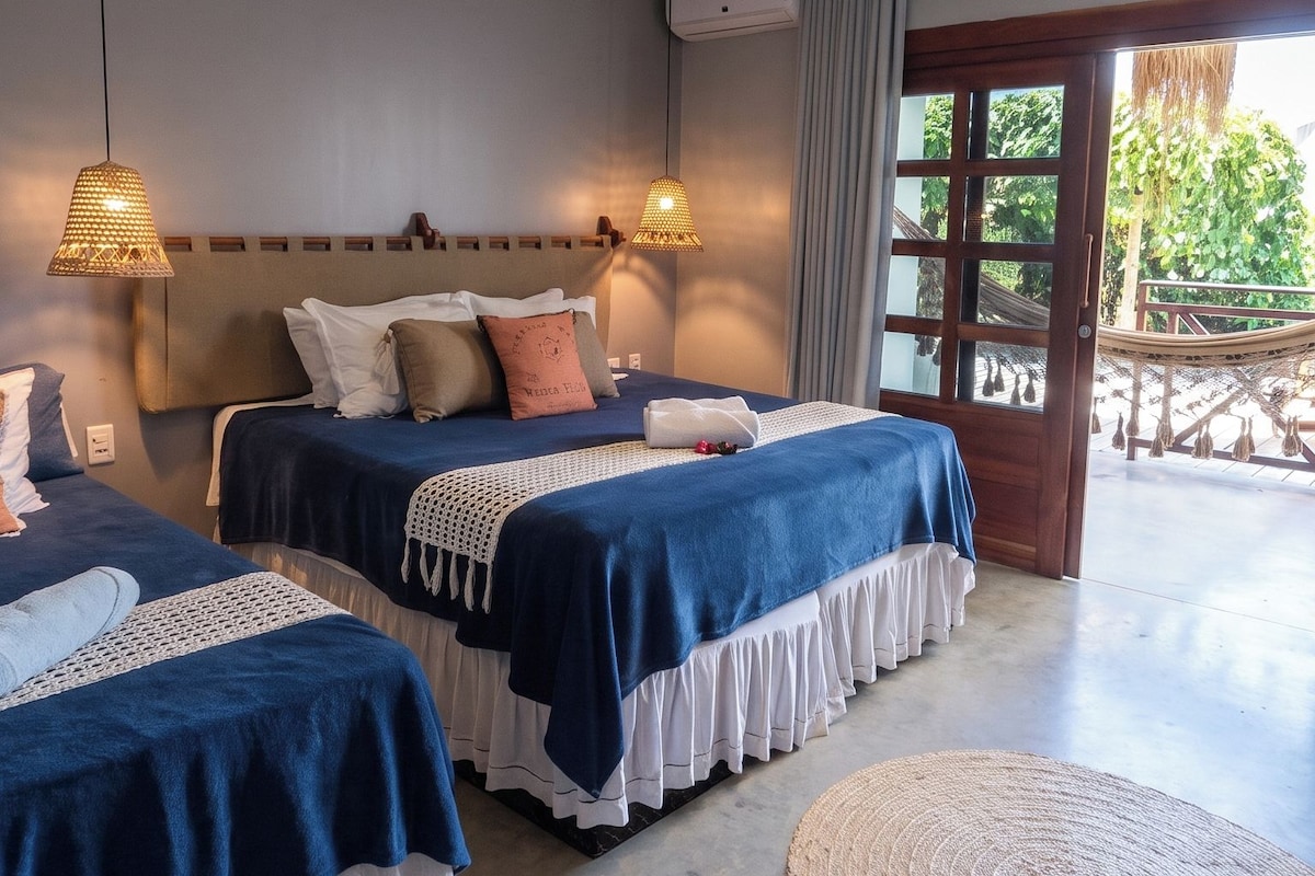 Une chambre d’hôtel avec deux lits, une grande fenêtre et une vue sur l’extérieur.