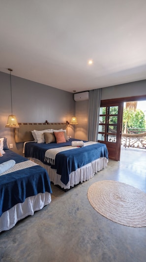 Une chambre d’hôtel avec deux lits, une grande fenêtre et une vue sur l’extérieur.