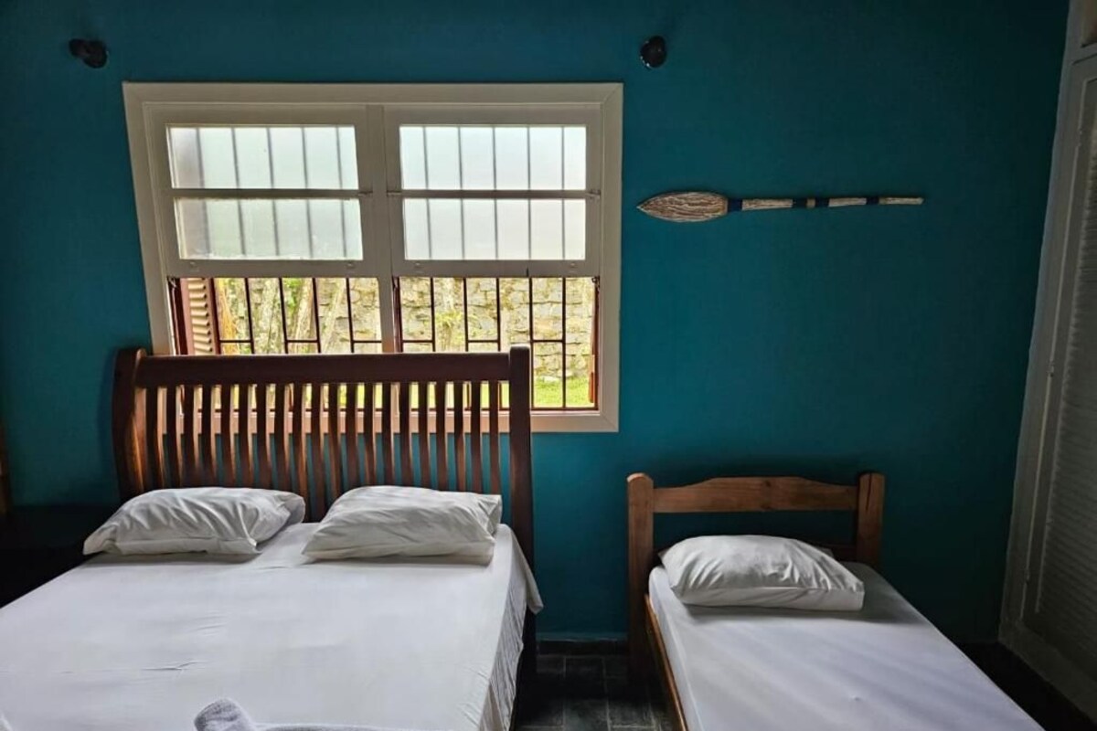 A room with two beds, a window, and a wall-mounted decorative item.
