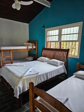 A room with bunk beds, a window with blinds, and a ceiling fan. - Pousada Nevada Enseada (Ubatuba)