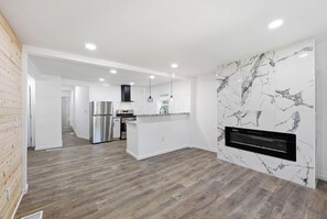 Una cocina moderna con horno integrado, electrodomésticos de acero inoxidable y un salpicadero de mármol.