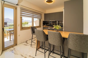 Eine moderne Küche mit Barbereich, Marmorböden und Blick ins Freie.