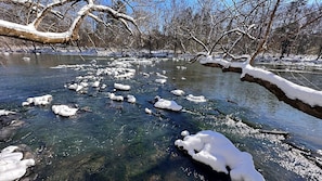 Un río con ramas cubiertas de nieve y hielo.