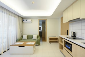 A modern hotel room with a kitchenette, a dining area, and a walk-in closet. - Sunset Rooftop Pool | 2BR near Kamala Beach | Gym 211 (Tambon Kamala)