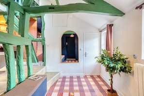 A hallway with a checkered floor, a door with a mirror, and a potted plant. - New Listing (Rouen)
