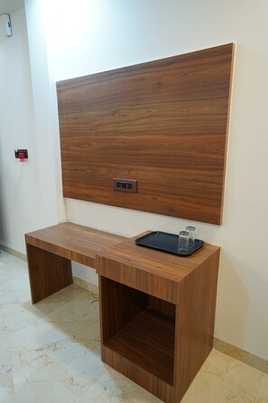 Mesa de madeira com bandeja e saleiros, uma tomada e um painel fixado na parede.