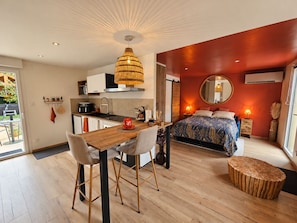 Een moderne slaapkamer met een bed, bedlampjes en een ronde spiegel.