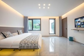 A modern hotel room with a large bed, two windows, a television on the wall, and a balcony. - xiang zi zai homestay (Huairou)