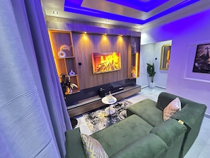 Una sala de estar moderna con una televisión de pantalla plana, un sofá y una mesa de centro.