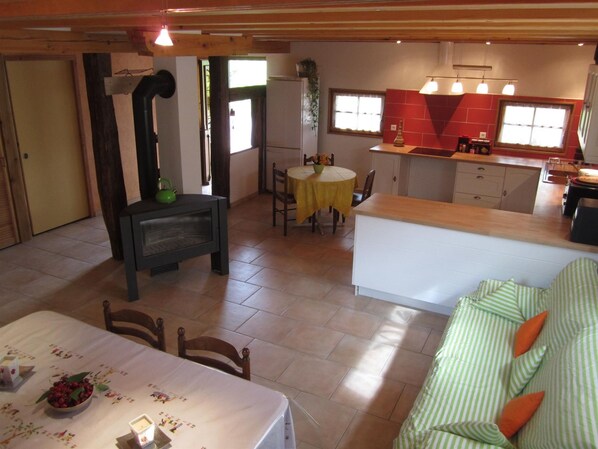 A cozy kitchen with a dining area, a built-in stove, and a window overlooking the garden.