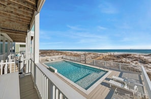 Una piscina en una terraza con vista a la playa.
