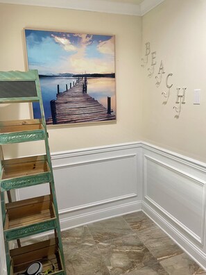 A room with a wooden ladder, a painting of a pier, and a wall with the word 'BEACH' spelled out. - 4 Bedroom Rooftop Retreat in beautiful Seaside Heights (Seaside Heights)