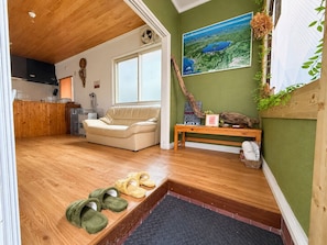 A cozy living area with a sofa, a bench, and a small table with a picture frame.
