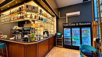 A bar area with a liquor display and a cold cuts & sauces refrigerator.