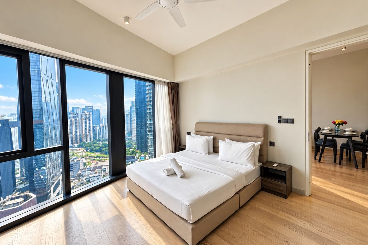 A modern hotel room with a large bed, a ceiling fan, and a city view through floor-to-ceiling windows.