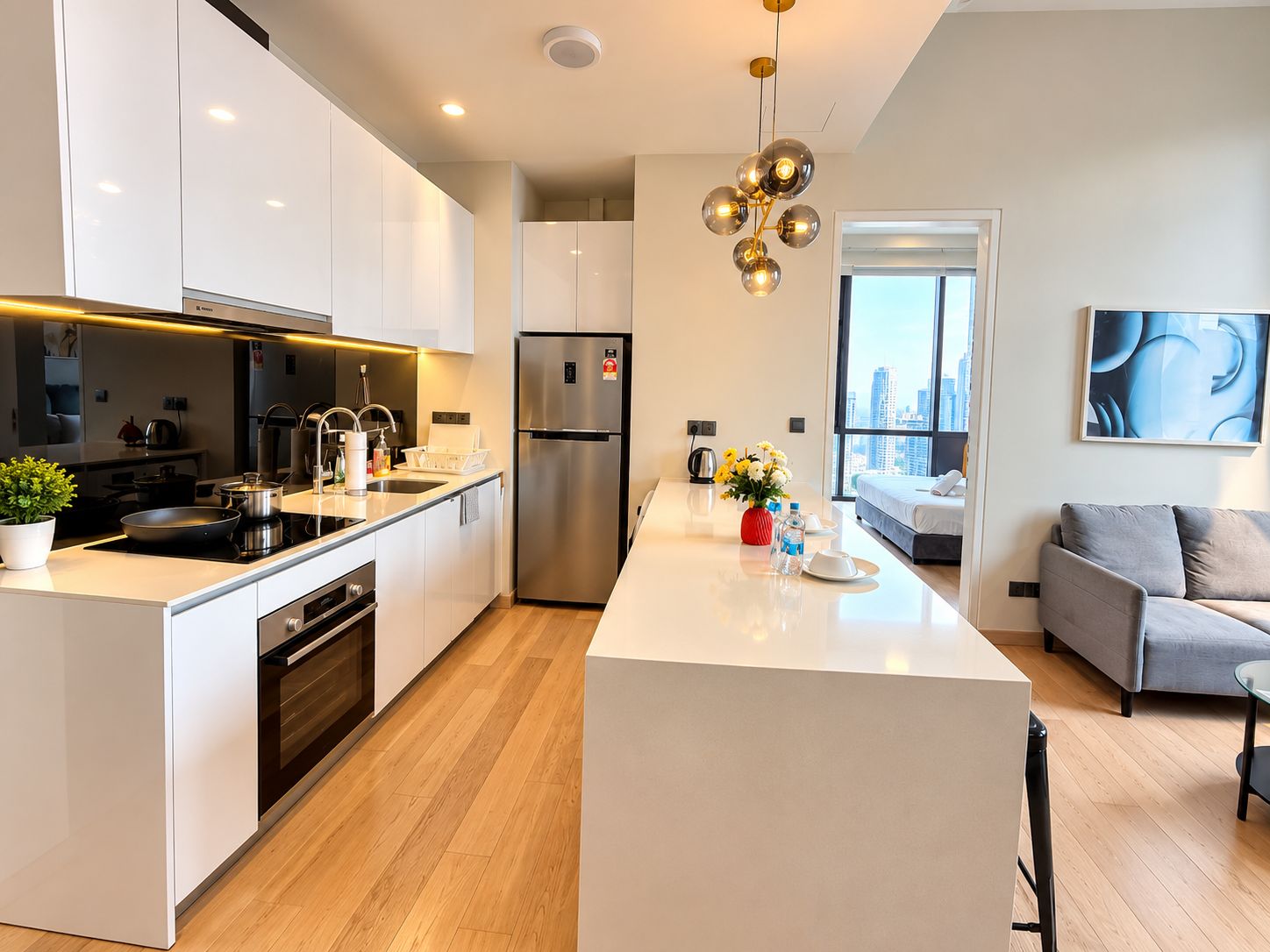A modern kitchen with a central island, stainless steel appliances, and a view to the living area.